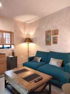 a living room with a blue couch and a coffee table at Verde Oliva loft in Vejer de la Frontera