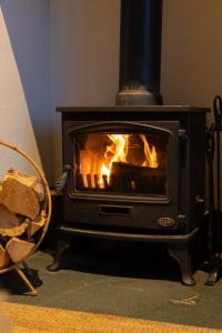 a stove with a fire in a room at Harbour Cottage, Conwy in Conwy