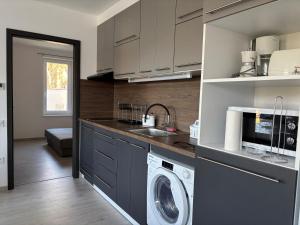 a kitchen with a washer and dryer in it at Pipacs 17 by HelloBalatonlelle in Balatonlelle