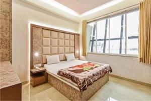 a bedroom with a bed and a large window at Holiday Aapke Liye V Hotel in Khopoli
