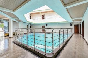 a large swimming pool in a large room with a ceiling at Holiday Aapke Liye V Hotel in Khopoli