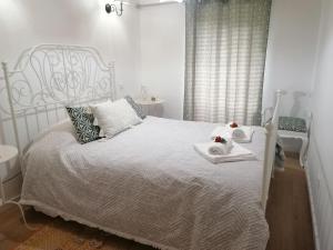 a bedroom with a white bed with two towels on it at Casinha Pôr do Sol in Aldeia das Dez
