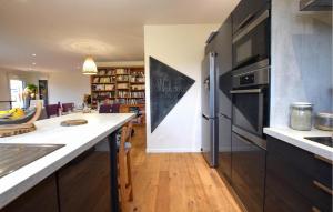 a kitchen with a refrigerator and a dining room at 3 Bedroom Nice Home In Amfreville in Amfréville +17 photos