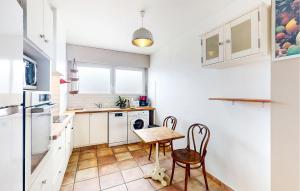 a kitchen with a table and two chairs in it at Nice Apartment In Saint-Paul-Lès-Dax in Saint-Paul-lès-Dax