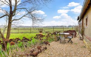 a patio with a table and chairs and a field at Lovely Home In Les Baux De Breteuil in Les Baux-de-Breteuil +11 photos