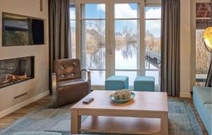 a living room with a couch and a table and a fireplace at Bodelaeke-Schiphuis Wellness 8 in Giethoorn