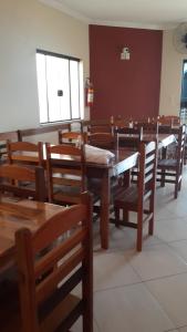 een eetkamer met houten tafels en stoelen bij Pousada São Nicolau in Cachoeira Paulista +10 foto's