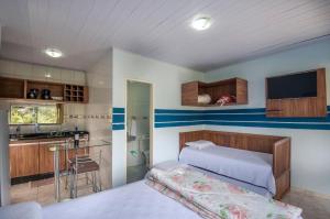 a small bedroom with a bed and a kitchen at Pousada Bela Vista do Capão in Palmeiras
