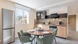 a kitchen with a table and chairs and a refrigerator at Le Dauphiné 7 Allevard in Allevard