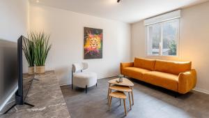 a living room with a couch and a tv at Le Dauphiné 7 Allevard in Allevard