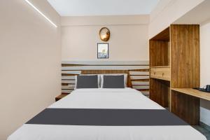 Postel nebo postele na pokoji v ubytování Super Hotel O Vilankurichi