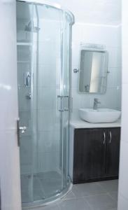 a bathroom with a glass shower and a sink at The Serenity Space in Pātan
