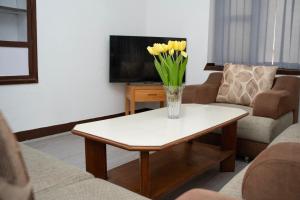 a vase of flowers on a coffee table in a living room at The Serenity Space in Pātan