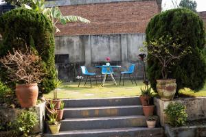 a garden with a table and chairs and stairs at The Serenity Space in Pātan