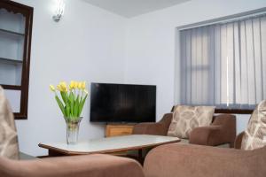 a living room with a vase of flowers on a table at The Serenity Space in Pātan