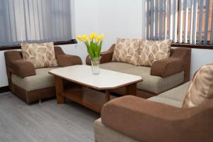 a living room with couches and a vase of flowers on a table at The Serenity Space in Pātan
