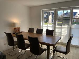 a dining room with a wooden table and chairs at Ferienhaus Sonnenblick in Timmendorfer Strand