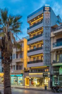ein hohes Gebäude mit einer Palme davor in der Unterkunft CITY NEST Living in Iraklio