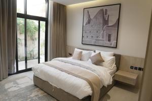 a bedroom with a large bed and a window at Voyage Itlalat Resort منتجع وشاليهات فوياج اطلالات in Al ‘Uyaynah +146 photos