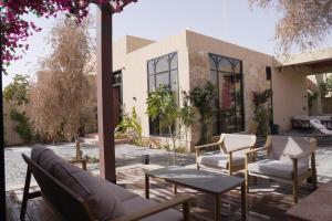 a patio with chairs and a table and a building at Voyage Itlalat Resort منتجع وشاليهات فوياج اطلالات in Al ‘Uyaynah