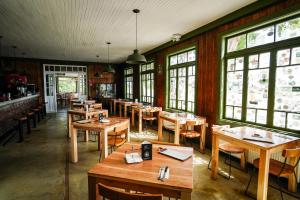 ein Restaurant mit Holztischen und -stühlen und Fenstern in der Unterkunft Hotel Río Rubens in Casas Viejas