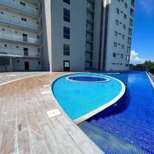 a large blue swimming pool in the middle of a building at departamento en riviera veracruzana in Conchal