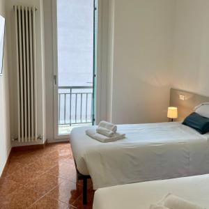 ein Schlafzimmer mit zwei Betten und einem großen Fenster in der Unterkunft Bnbook Quadrilocale Italia in Rho + 28 Fotos