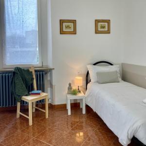 ein Schlafzimmer mit einem Bett, einem Stuhl und einem Fenster in der Unterkunft Bnbook Quadrilocale Italia in Rho