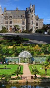 a large castle with a greenhouse in front of it at Maison de vacances 5 voyageurs in Cherbourg en Cotentin