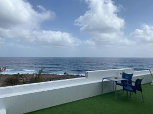 a balcony with a table and chairs and the ocean at Laranjinha Rooms in Paul