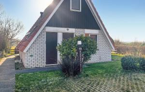 a house with a window and a bush in front of it at 3 Bedroom Nice Home In Den Oever in Den Oever