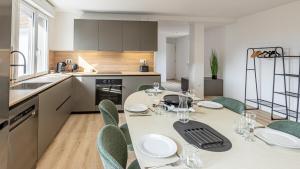 a kitchen with a table and chairs and a kitchen with a table and chairsktop at Le Dauphiné 10 Allevard in Allevard
