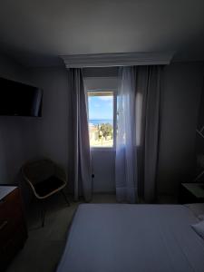 a bedroom with a window with a bed and a chair at Chalet with Sea Views in Fuengirola +24 photos
