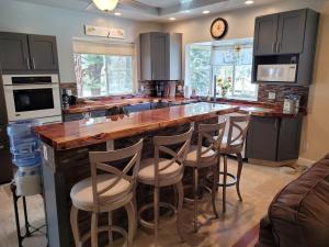 a kitchen with a large island with bar stools at Newly remodeled mountain home! in Floriston