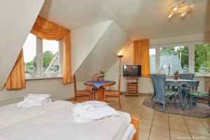 a bedroom with two beds and a table and chairs at Doppelzimmer mit kleiner Pantryküche Gästehaus Unter den Linden in Mühbrook