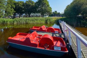 three red boats are parked next to a dock at Doppelzimmer mit kleiner Pantryküche Gästehaus Unter den Linden in Mühbrook +1 photo