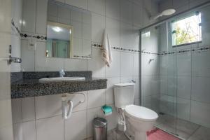a bathroom with a toilet and a sink and a shower at Pousada Bela Vista do Capão in Palmeiras +57 photos