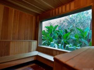 a room with a window in a room with plants at Pousada Spa Prana Lorien in Santo Antônio do Leite