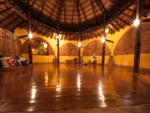 a large room with a wooden floor and a straw roof at Pousada Spa Prana Lorien in Santo Antônio do Leite