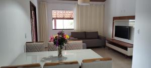 a living room with a table with a vase of flowers on it at Pousada Bela Vista do Capão in Palmeiras