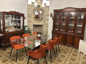a dining room with a glass table and orange chairs at Ca na Vilaneta in Caimari