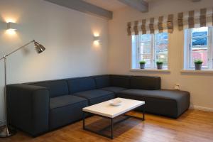 ein Wohnzimmer mit einem blauen Sofa und einem Tisch in der Unterkunft Haus Boldix Whg 6 St Barth in Boldixum