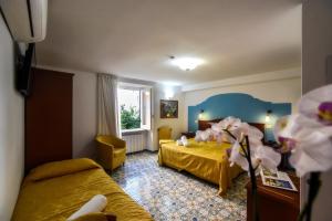a hotel room with two beds and a window at Amalfi Hotel centro storico in Amalfi