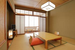 a living room with a table and a chair at ホテル レムナント鶯宿 in Shizukuishi