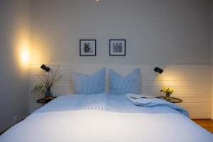 un lit blanc avec des oreillers bleus dans une chambre dans l'établissement Santa Ana, à Westermarkelsdorf