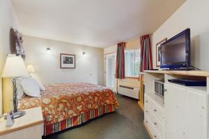 ein Hotelzimmer mit einem Bett und einem Flachbildfernseher in der Unterkunft Icicle Village Resort Condo #408 in Leavenworth