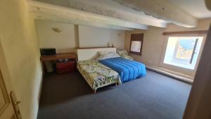 a bedroom with a bed and a desk and a window at Environnement calme et reposant - Côtes-d'Armor in Ploëzal