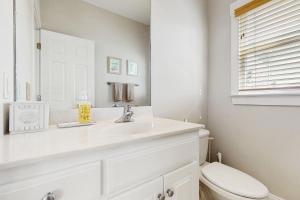 a white bathroom with a sink and a toilet at Scotchbonnet in North Topsail Beach +13 photos