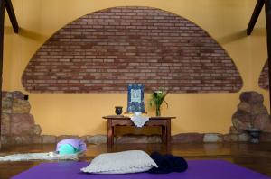 a room with a table and a brick wall at Pousada Spa Prana Lorien in Santo Antônio do Leite