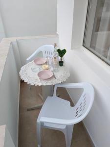 a white table with a white chair and a table with a plate at Стаи за гости Ники in Nesebar